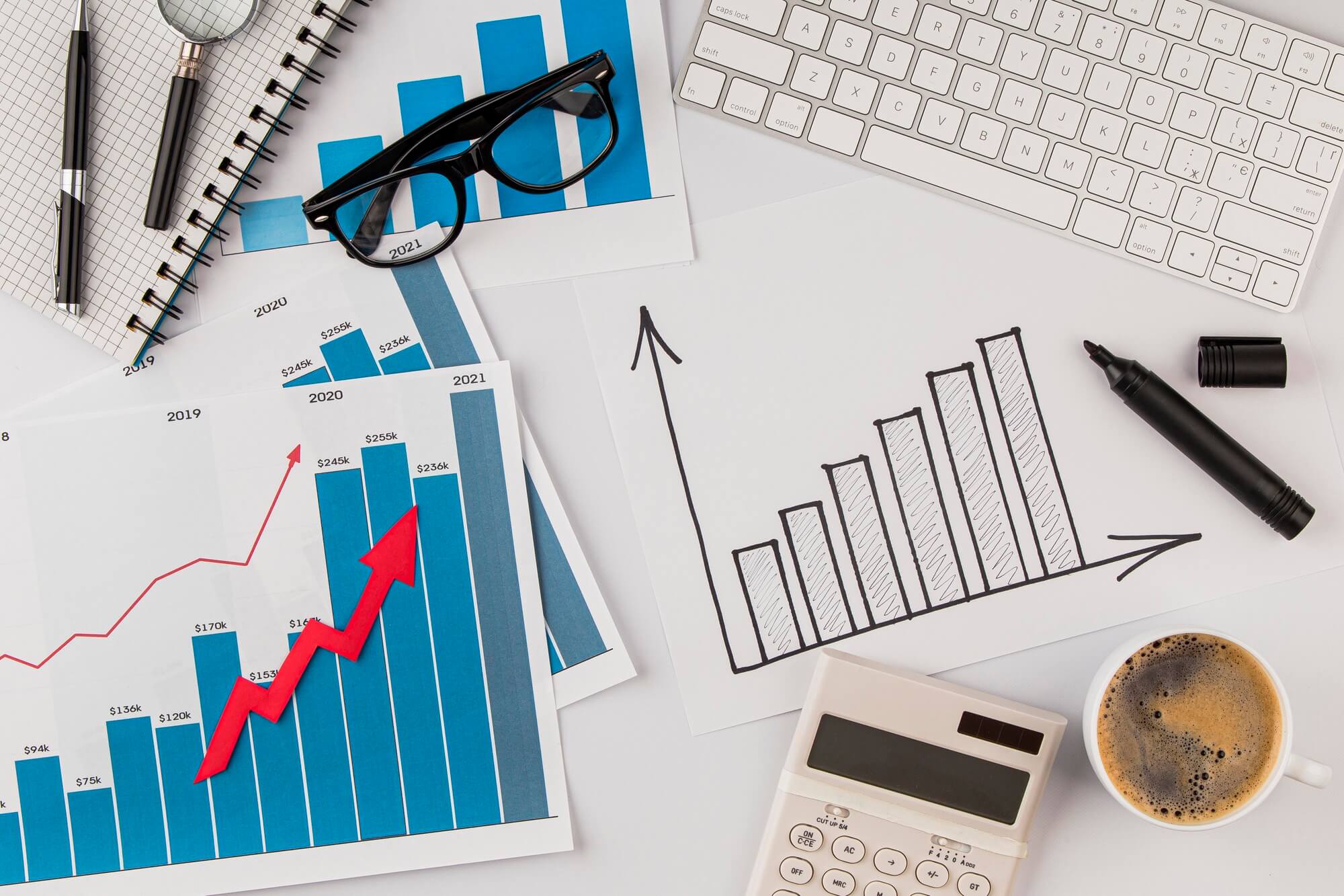 top-view-office-desk-with-growth-chart-glasses (1)
